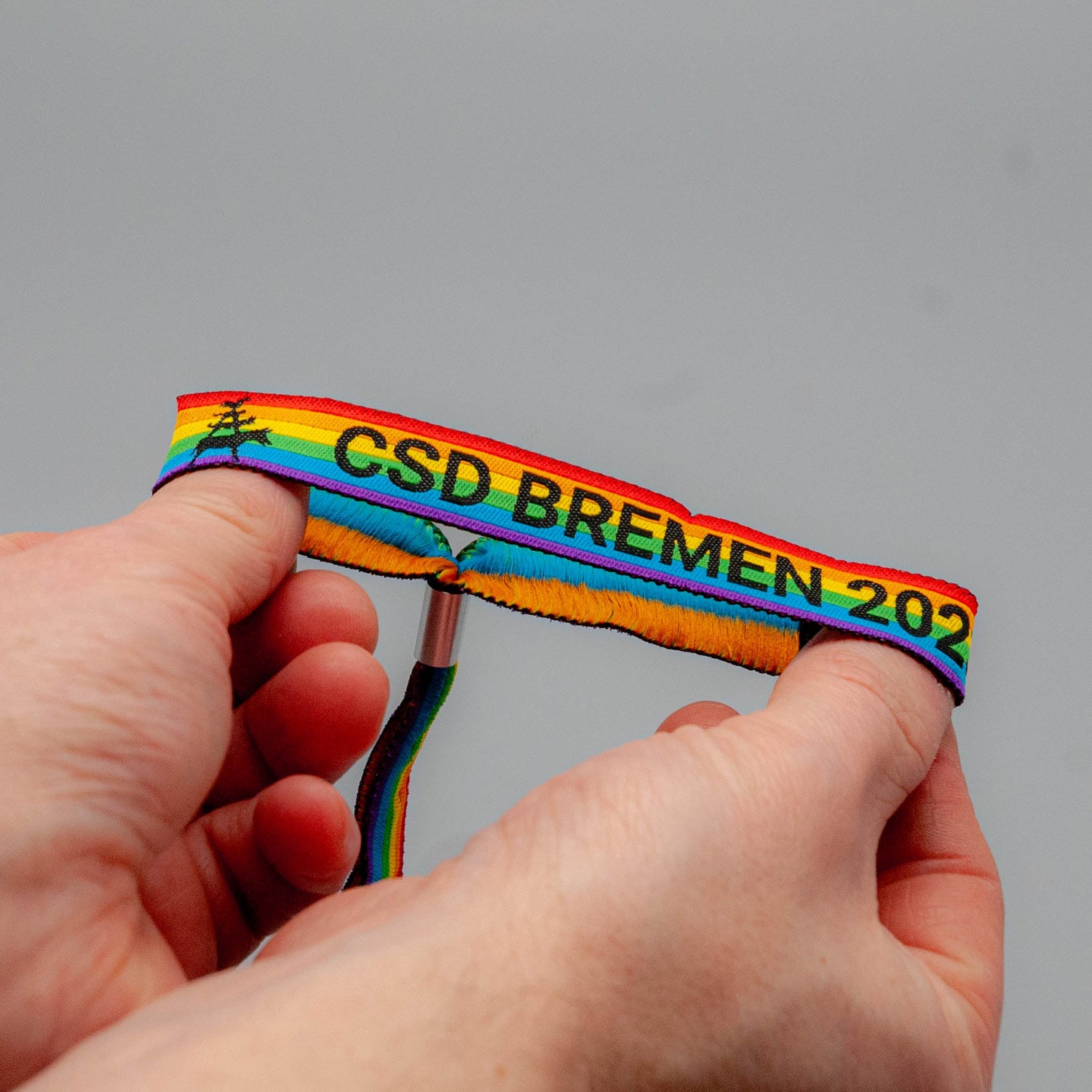 ein bild des csd bremen bändchens in regenbogenfarben.